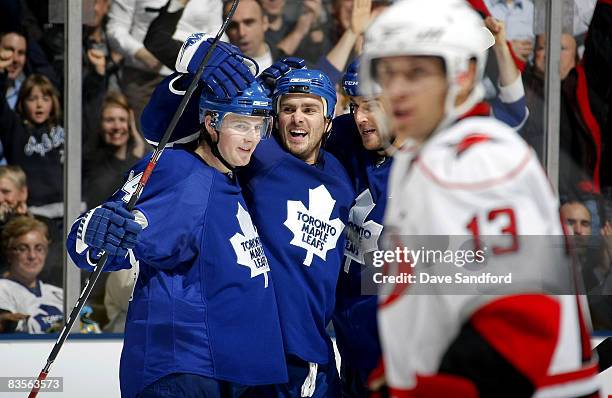 Mike Van Ryn of the Toronto Maple Leafs celebrates his goal with teammates Matt Stajan and Pavel Kubina as Ray Whitney of the Carolina Hurricanes...