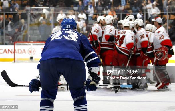 Members of the Carolina Hurricanes clebrate their overtime win as Alexei Ponikarovsky of the Toronto Maple Leafs looks on during their NHL game at...