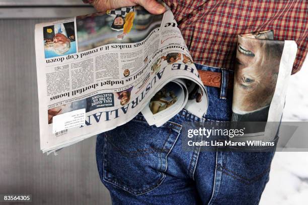 Man has a newspaper showing a photograph Senator John McCain in his pocket as he watches the US election results on tv at The American Club on...