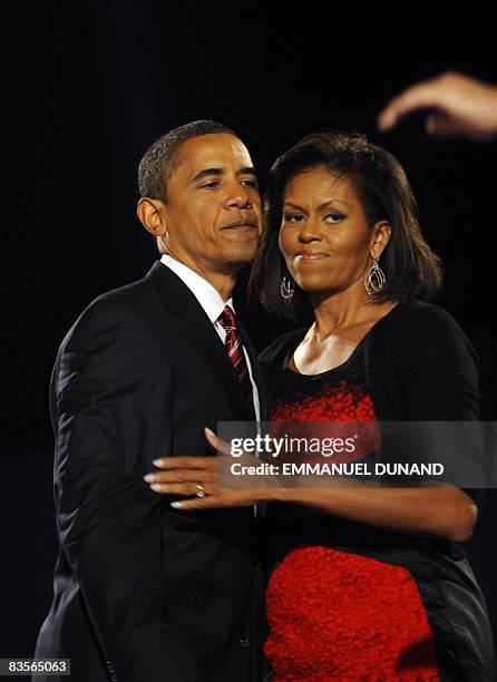 Democratic presidential candidate Barack Obama and his wife Michelle embrace on stage during Obama's election night victory rally at Grant Park on...