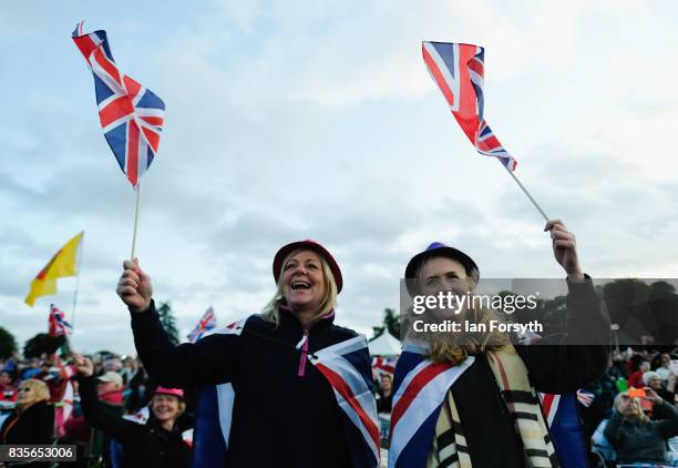 Two women wave flags as they join thousands of spectators attending the annual Castle Howard Proms Spectacular concert held on the grounds of the...