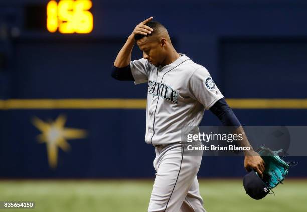 Pitcher Ariel Miranda of the Seattle Mariners makes his way to the dugout after being taken off the mound by manager Scott Servais after allowing a...