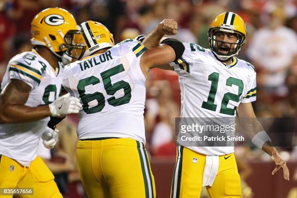 Quarterback Aaron Rodgers of the Green Bay Packers celebrates a touchdown pass with teammate Lane Taylor against the Washington Redskins in the first...