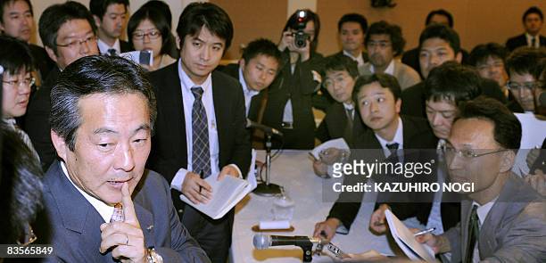 Japan's Sanyo Electric Co. President Seiichiro Sano is surrounded by reporters after a press conference to announce the company's financial results...