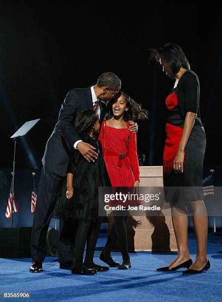 President elect Barack Obama stands on stage along with his wife Michelle and daughters Malia and Sasha during an election night gathering in Grant...