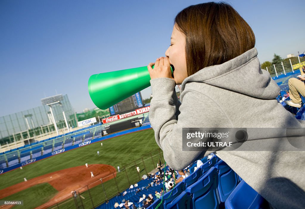 A girl cheers in a ballpark.