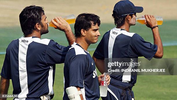 Indian cricketers Mahendra Singh Dhoni , Sourav Ganguly and Subramanium Badrinath drinks fluids during a training session at the VCA cricket stadium...