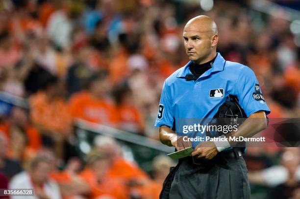 Home plate umpire Vic Carapazza wears a white wristband in the sixth inning during a game between the Los Angeles Angels of Anaheim and Baltimore...