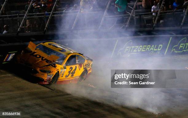 Landon Cassill, driver of the Love's Travel Stops Ford, spins during the Monster Energy NASCAR Cup Series Bass Pro Shops NRA Night Race at Bristol...