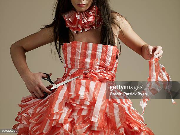 woman with scissors and plastic bag dress - newcraft stock-fotos und bilder