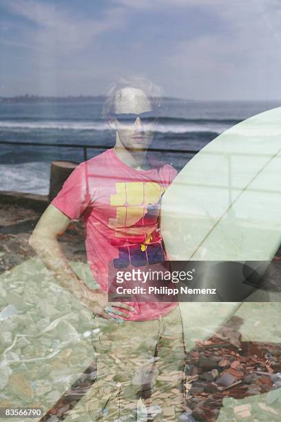 surfer with board behind window watching waves - philipp nemenz bildbanksfoton och bilder