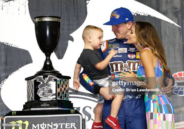 Kyle Busch, driver of the M&M's Caramel Toyota, celebrates in victory lane with his wife, Samantha, and son, Brexton, after winning the Monster...