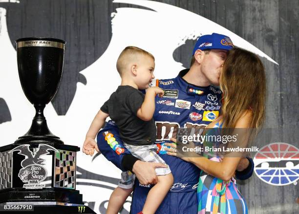 Kyle Busch, driver of the M&M's Caramel Toyota, celebrates in victory lane with his wife, Samantha, and son, Brexton, after winning the Monster...