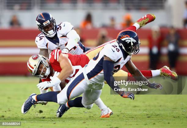 Vance McDonald of the San Francisco 49ers is tackled by Will Parks and Darian Stewart of the Denver Broncos at Levi's Stadium on August 19, 2017 in...