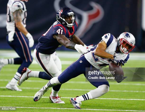 Foster of the New England Patriots makes a catch in front of Zach Cunningham of the Houston Texans at NRG Stadium on August 19, 2017 in Houston,...