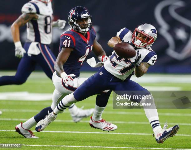 Foster of the New England Patriots makes a catch in front of Zach Cunningham of the Houston Texans at NRG Stadium on August 19, 2017 in Houston,...