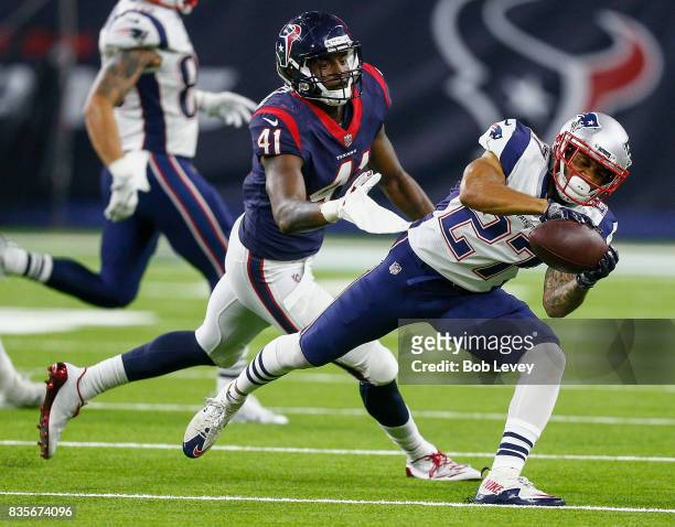 Foster of the New England Patriots makes a catch in front of Zach Cunningham of the Houston Texans at NRG Stadium on August 19, 2017 in Houston,...