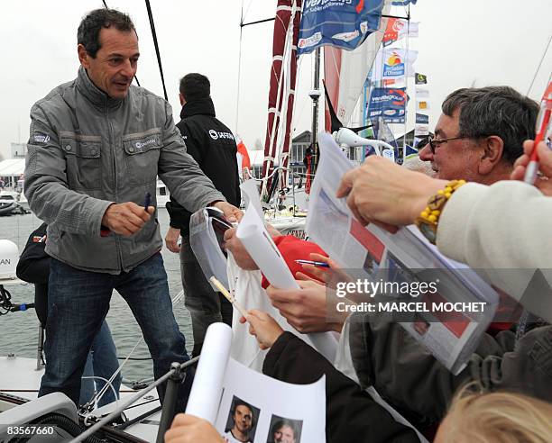 French skipper Marc Guillemot , signs autographs on board of his 60-feet-long "Safran" monohull on November 5, 2008 at Les Sables-d'Olonne's harbour,...