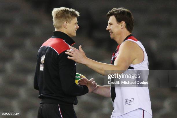 Former Saints player Justin Koschitzke catches up with Nick Riewoldt of the Saints while he plays in the Legends Match as a curtain raiser during the...