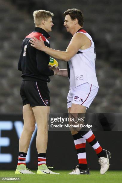 Former Saints player Justin Koschitzke catches up with Nick Riewoldt of the Saints while he plays in the Legends Match as a curtain raiser during the...