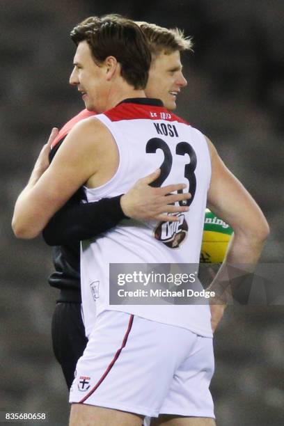 Former Saints player Justin Koschitzke catches up with Nick Riewoldt of the Saints while he plays in the Legends Match as a curtain raiser during the...