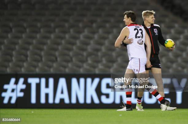 Former Saints player Justin Koschitzke catches up with Nick Riewoldt of the Saints while he plays in the Legends Match as a curtain raiser during the...