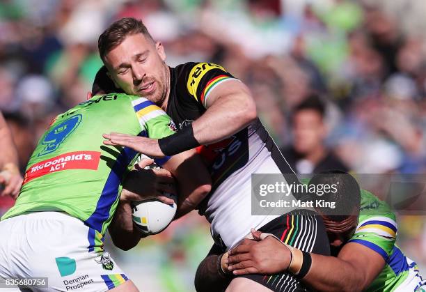 Bryce Cartwright of the Panthers is tackled during the round 24 NRL match between the Canberra Raiders and the Penrith Panthers at GIO Stadium on...