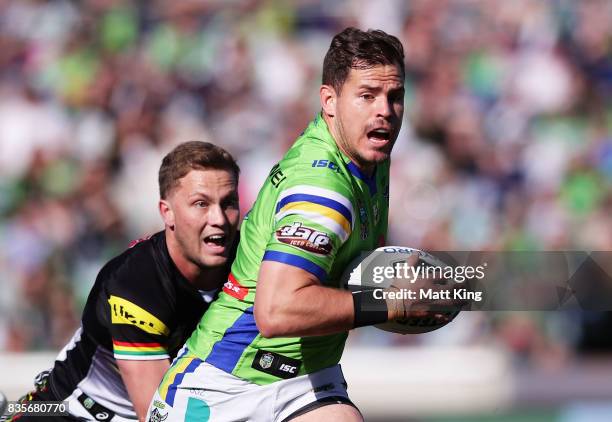 Aidan Sezer of the Raiders gets away from Matt Moylan of the Panthers during the round 24 NRL match between the Canberra Raiders and the Penrith...