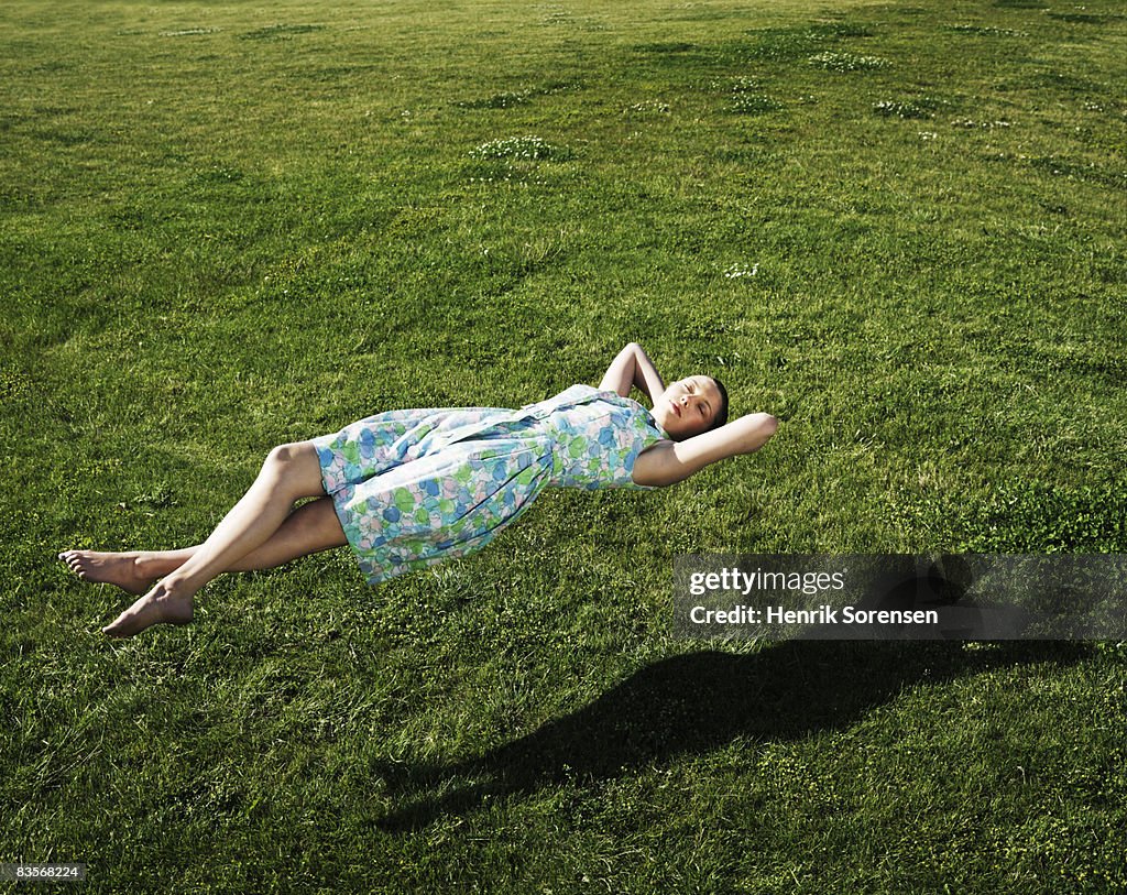 Woman realxing floating above the grass