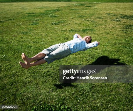 Man realxing floating above the grass Man realxing floating above the grass