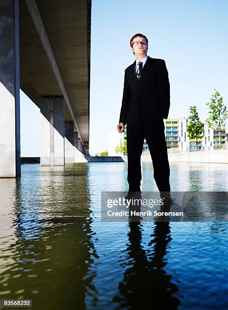 business man standing on the water - ankle deep in water fotografías e imágenes de stock