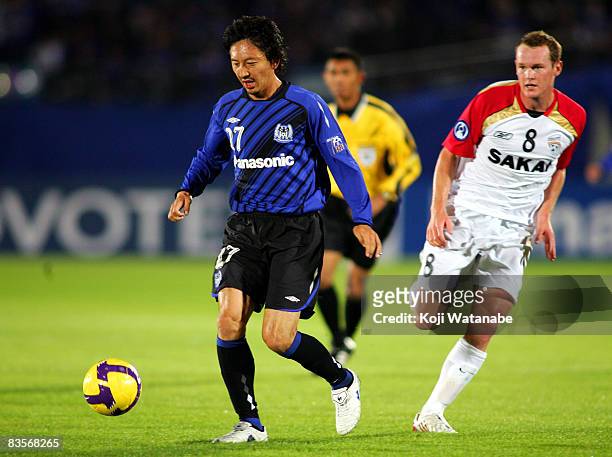 Hideo Hashimoto of Gamba Osaka and Kristian Sarkies of Adelaide United compete for the ball during AFC Champions League Final first leg match between...