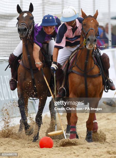 Teams compete during the British Beach Polo Championships from under raincoats and umbrellas at the exclusive Sandbanks area of Poole, Dorset.