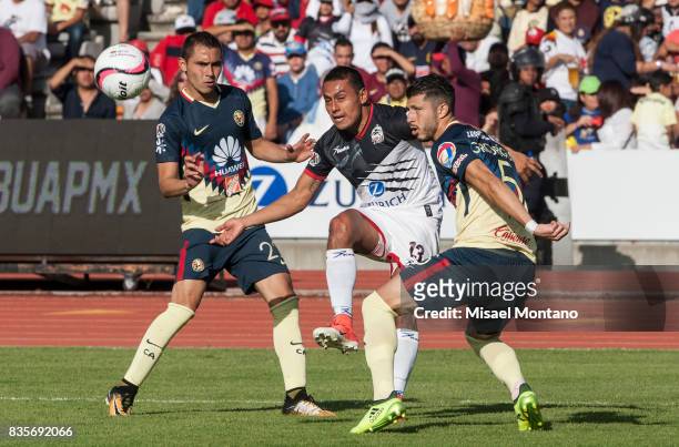 Omar Tejada of Lobos BUAP fights for the ball with Paul Aguilar and Javier Guemez of America during the fifth round match between Lobos BUAP and...