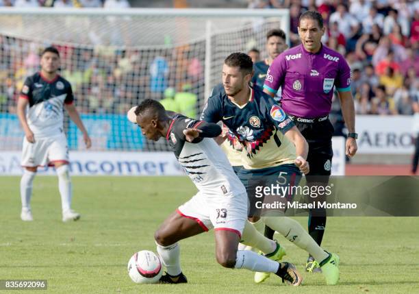 Julian Quiñones of Lobos BUAP competes for the ball with Guido Rodriguez of America during the fifth round match between Lobos BUAP and America as...