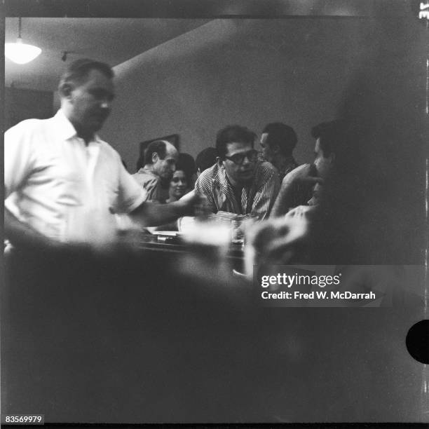 Bartender John Bodner servers drinks at the Cedar Street Tavern, New York, New York, August 19, 1959. Over his left arm, American theatre director...