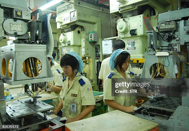 Chinese workers produce various components at the Mansfield Manufacturing plant in Dongguan, southern China's Guangdong province on October 20, 2008....