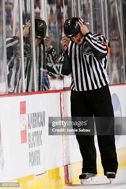 Referee Gord Dwyer confers with off-ice officials while reviewing a goal during a game between the Columbus Blue Jackets and Chicago Blackhawks on...