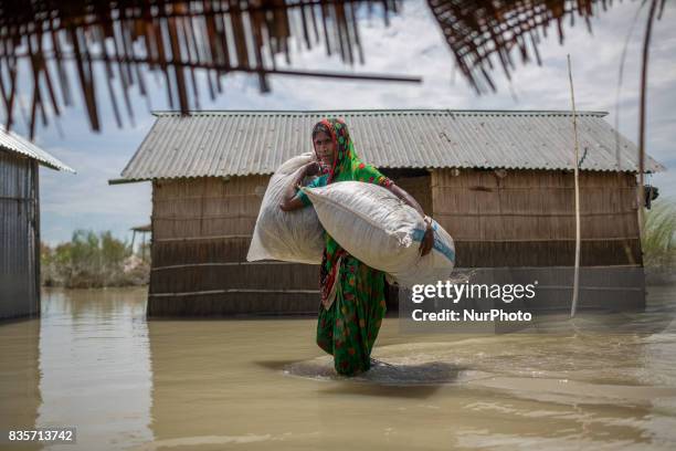 Woman is carrying her important households through flood water in a flood affected village of Gaibandha, Bangladesh. August 19, 2017. Gaibandha is a...