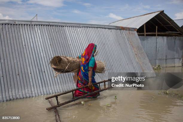 Woman is carrying her important households through flood water in Gaibandha, Bangladesh. August 19, 2017. Gaibandha is a district in Northern...