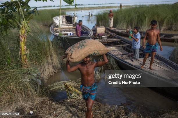 Man is carrying her important households through flood water in a flood affected village of Gaibandha, Bangladesh. August 19, 2017. Gaibandha is a...