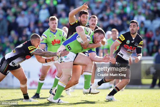 Shannon Boyd of the Raiders is tackled during the round 24 NRL match between the Canberra Raiders and the Penrith Panthers at GIO Stadium on August...