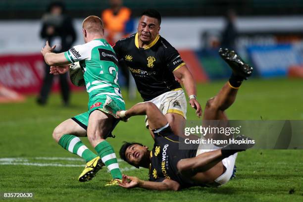 Jamie Booth of Manawatu is tackled by Asafo Aumua and Julian Savea of Wellington during the round one Mitre 10 Cup match between Manawatu and...