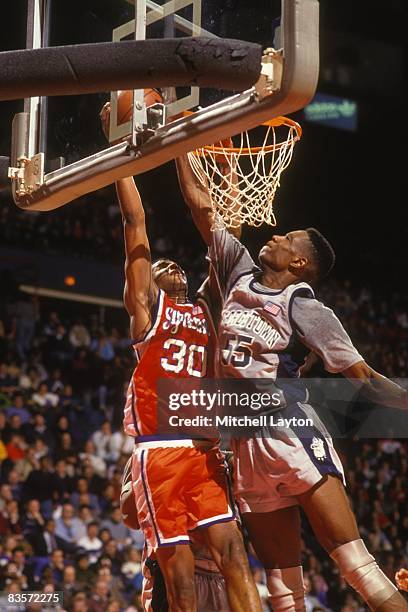 Billy Owens of the Syracuse Orangeman takes a shot over Dikembe Mutombo of the GEorgetown Hoyas during a college basketball game at Capitol Centre on...