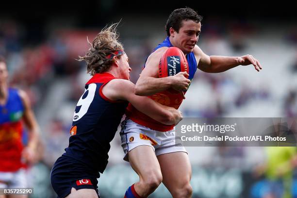 Lewis Taylor of the Lions and Jayden Hunt of the Demons contest the ball during the round 22 AFL match between the Melbourne Demons and the Brisbane...