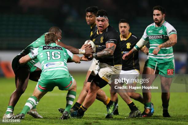 Alex Fidow of Wellington looks to evade the tackles of Willy Ambaka and Tim Cadwallader of Manawatu during the round one Mitre 10 Cup match between...
