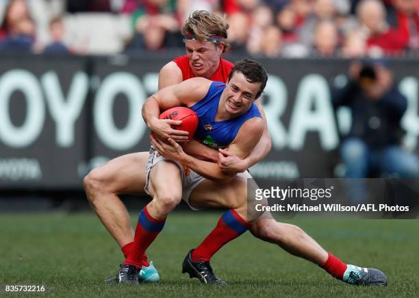 Lewis Taylor of the Lions is tackled by Jayden Hunt of the Demons during the 2017 AFL round 22 match between the Melbourne Demons and the Brisbane...