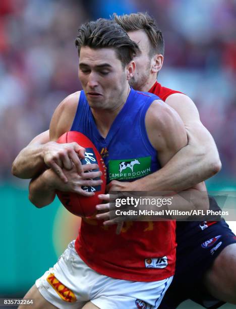 Jacob Allison of the Lions is tackled by Dom Tyson of the Demons during the 2017 AFL round 22 match between the Melbourne Demons and the Brisbane...