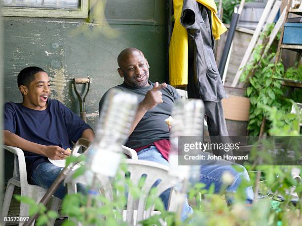 father and teenage son eating lunch on alottment - multi ethnic group of kids stock pictures, royalty-free photos & images