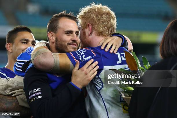 Departing Bulldogs player Josh Reynolds embraces James Graham of the Bulldogs on stage after a presentation to the players and officials leaving the...